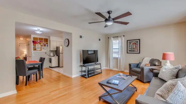 A living room with a sofa, coffee table, TV, and dining area with chairs and a table. - Spacious | Quiet | 1 bedroom duplex w free parking! (St. Louis)