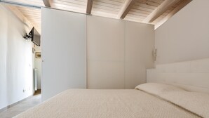 A bedroom with a large bed, a wardrobe, and a ceiling fan. - 2522 Trullo Monte Cannone - Appartamento 2 by Perle di Puglia (Fasano)