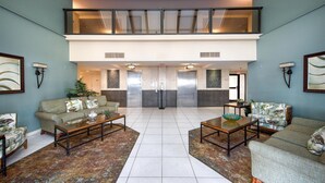 Un hall d’entrée spacieux, avec deux canapés, une table basse et un tapis à motifs.