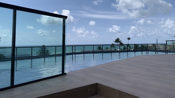 A rooftop pool with a glass balustrade overlooking the ocean. - POUSADA AMADA TERRA (Ipojuca)