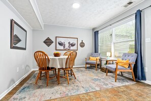 A dining area with a table, chairs, and a rug. - King bed 3 bedroom Townhouse close to Toomers! (Auburn)
