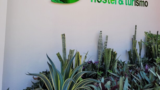 Una pared con un logotipo verde y el texto "Gurimã hostel & turismo".