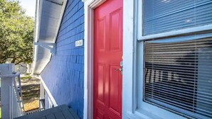 A house with a red door and a window with blinds.