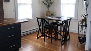 Una cocina moderna con encimera de madera, sillas negras y un ventilador de techo.