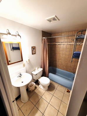 Un baño con lavamanos, inodoro, bañera y cortina de ducha.
