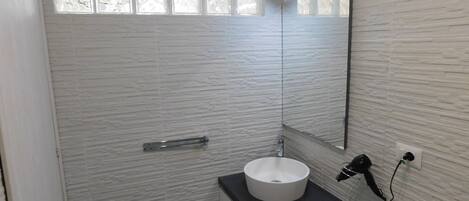 A bathroom with a white sink, a mirror, and a toilet.