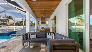 A modern outdoor living area with a pool, a wooden ceiling, and a glass wall. - Serenity retreat * the ultimate luxury getaway (Naples)