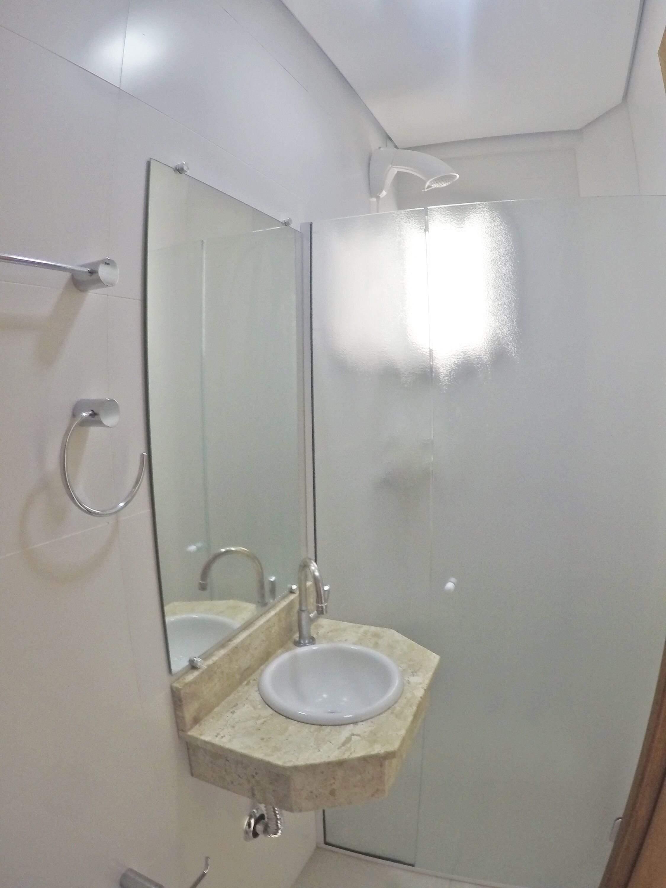 Une salle de bain avec un grand miroir, deux lavabos et une douche.