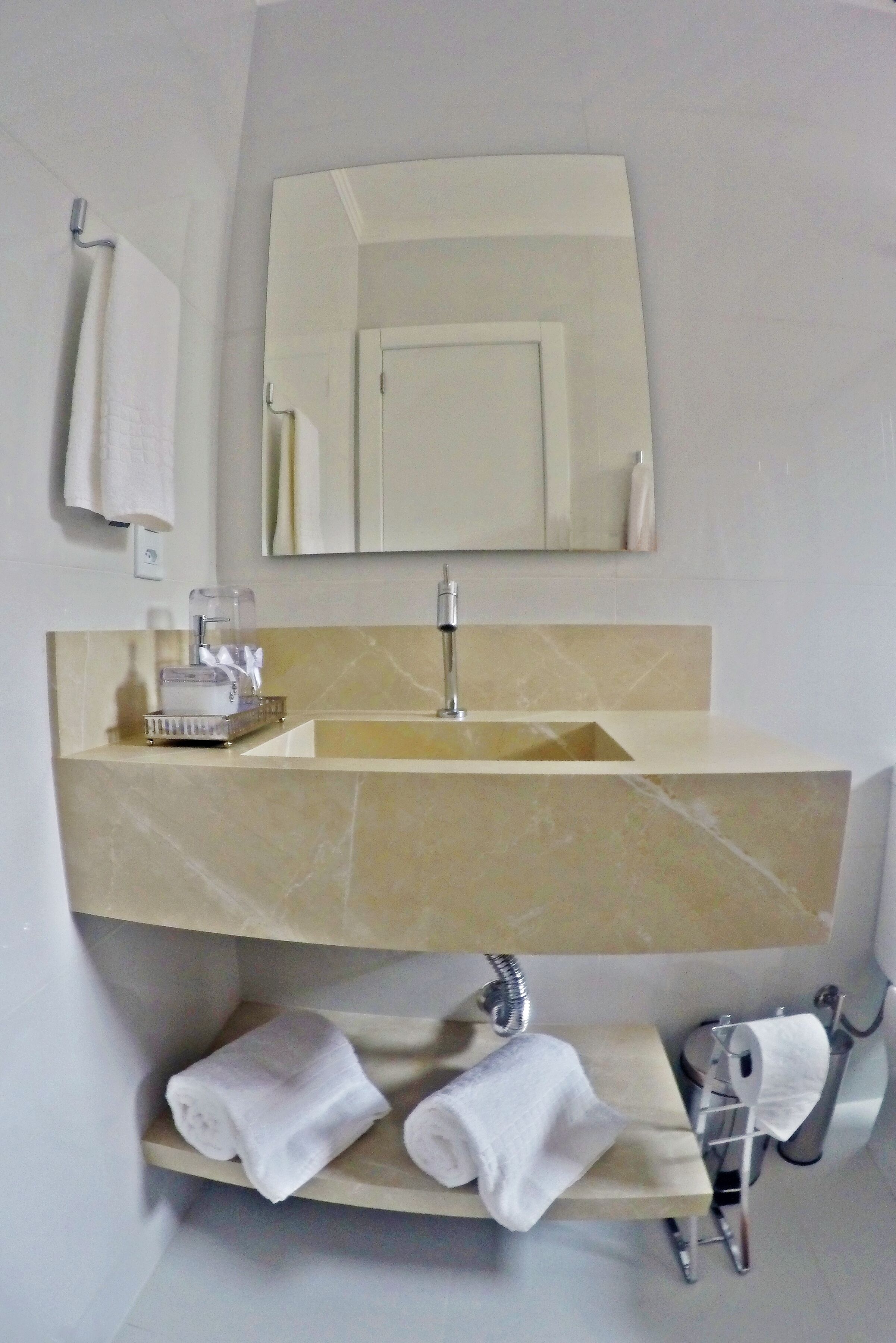 Une salle de bain avec un lavabo en marbre, un miroir et un porte-serviettes.