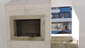 A compact kitchen with a built-in oven, a sink, and a gas cylinder. - MORADA PINHEIRO (Bombinhas)