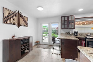 Una cocina moderna con una isla central, armarios de madera oscura y un elemento decorativo en la pared.