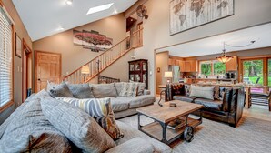 A spacious living room with a large sectional sofa, a wooden coffee table, and a staircase leading to an upper level. - Family & Pet Retreat-2 Amazing Game Rooms-FencedYd-Pool-Beach-JimThorpe-Speedway (Albrightsville)