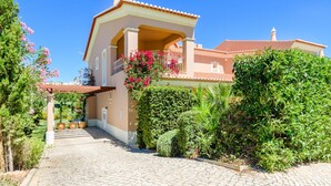 A two-story house with a covered porch, a tiled roof, and lush greenery. - Casa Mapie - Boavista Golf Resort Spa (Lagos)