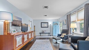 A living room with a wooden cabinet, TV, and seating area.