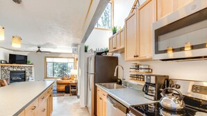 Eine moderne Küche mit einer großen Kochinsel, Edelstahlgeräten und Holzausbau.