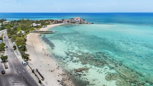 A coastal hotel with a beach view, a pier, and a road leading to the beach. - Convenient Stay in the Heart of Sandyport Olde Towne (Nassau)