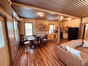 A compact living space with a dining area, kitchenette, and a sofa. - Texas Blue Apple | Pet-Friendly & Near Apple Store (Medina)