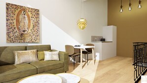 A modern living room with a green sofa, a white table, and a black chair. There is a painting on the wall and a hanging light fixture. - Residence d' Ouwe Kercke (Terneuzen)