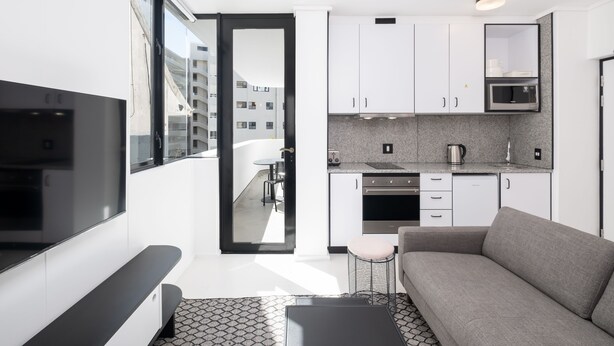 Un appartement moderne doté d’une kitchenette, d’un canapé et d’un coin repas.