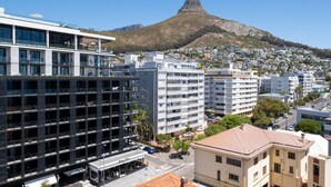 Un hôtel moderne à plusieurs étages, doté de grandes fenêtres et d’une terrasse sur le toit.