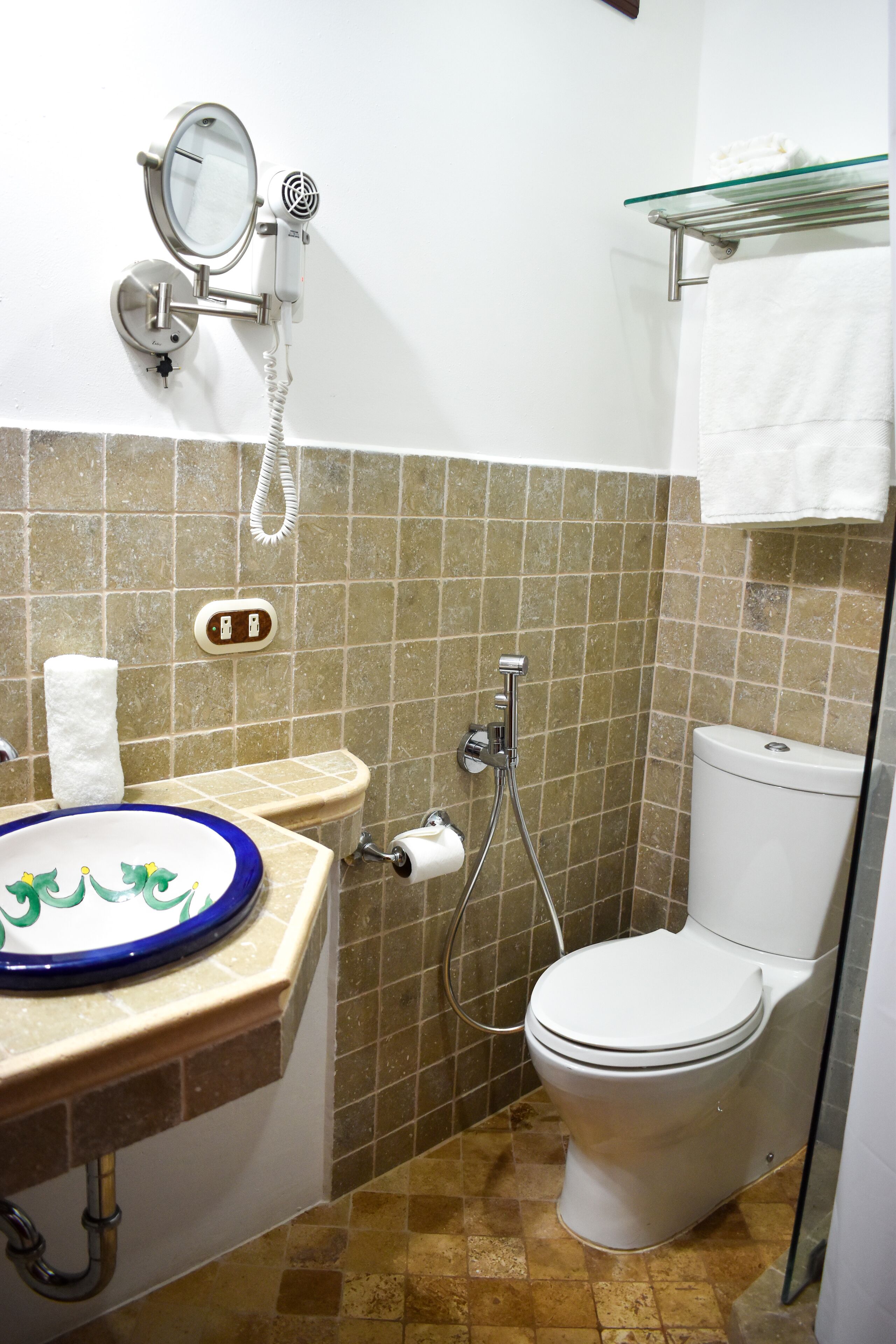 A bathroom with a sink, mirror, toilet, and shower.