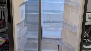 Un refrigerador moderno y vacío con estantes transparentes y sistema de enfriamiento total.