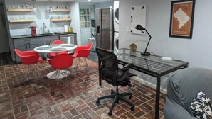 Un espacio habitable compacto con cocina, comedor y una pequeña oficina.