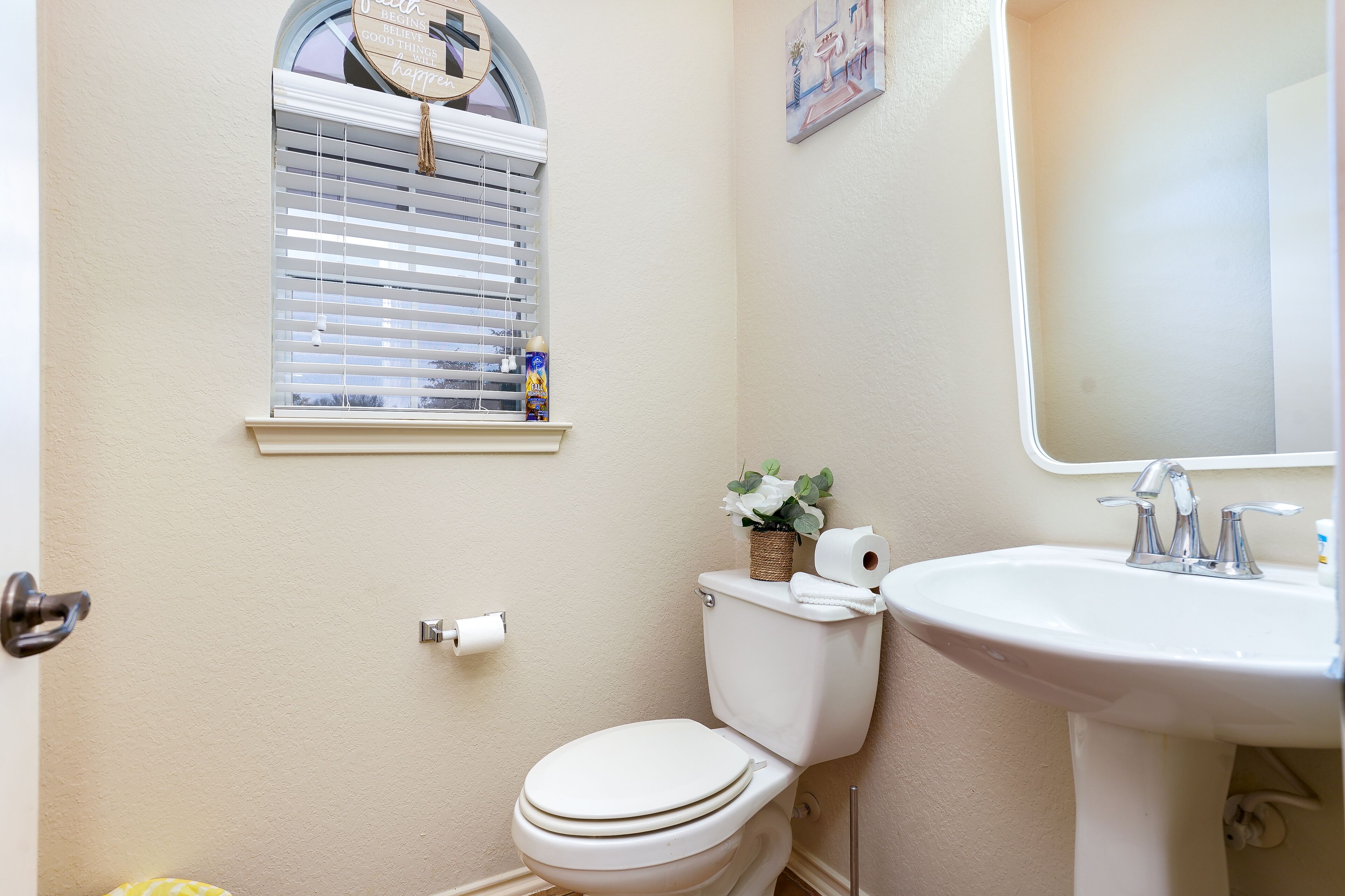 Un bagno con il water, un lavandino e una finestra con persiane.