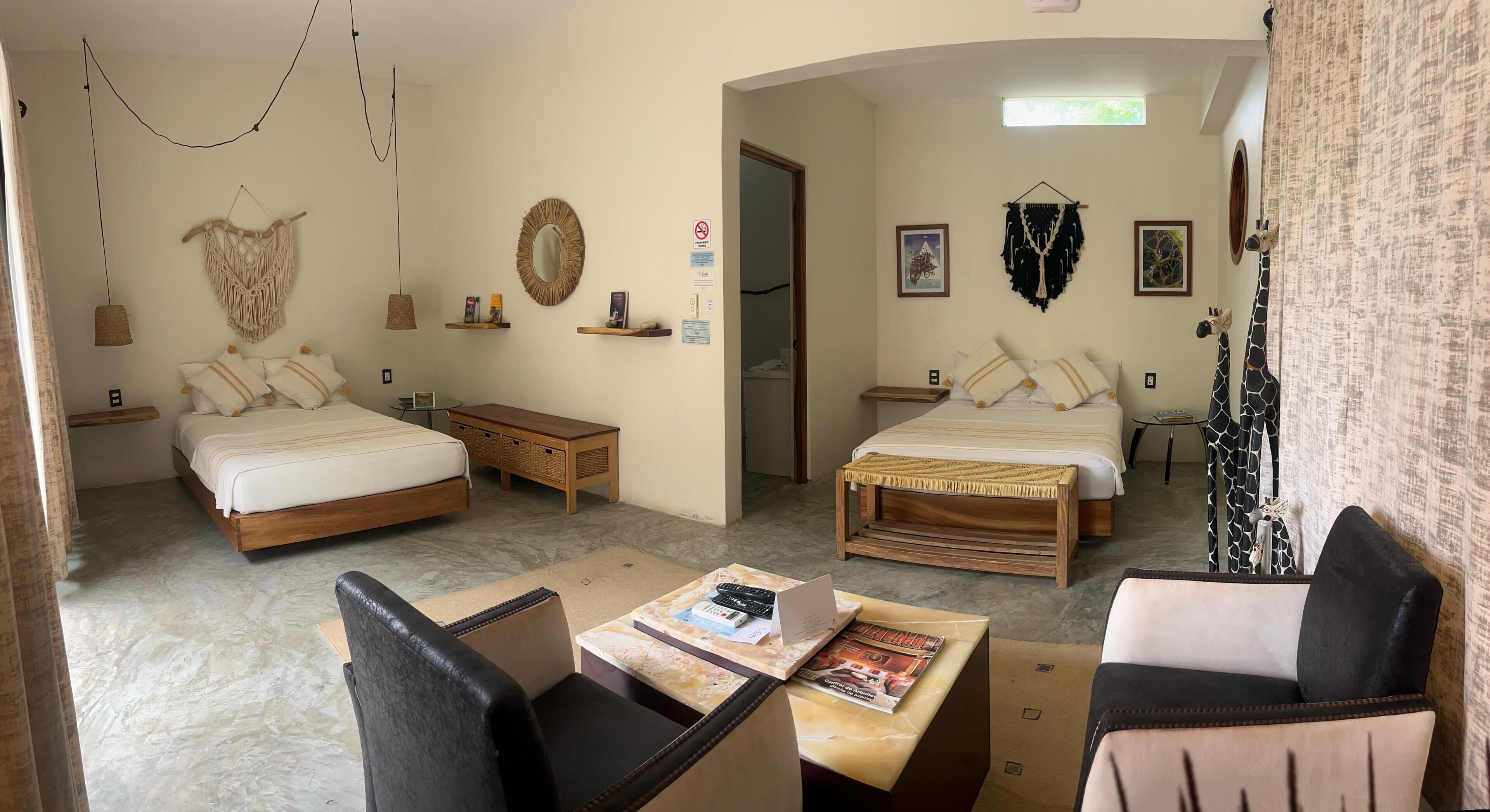 Una habitación de hotel con dos camas, un escritorio, una silla y una mesita.