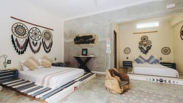 Quarto com duas camas, uma mesinha e decorações nas paredes.