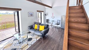 Ein modernes Wohnzimmer mit einer Couch, einem Glastisch und einem Essbereich.