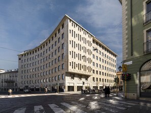 A multi-story building with a symmetrical facade, large windows, and a corner entrance.