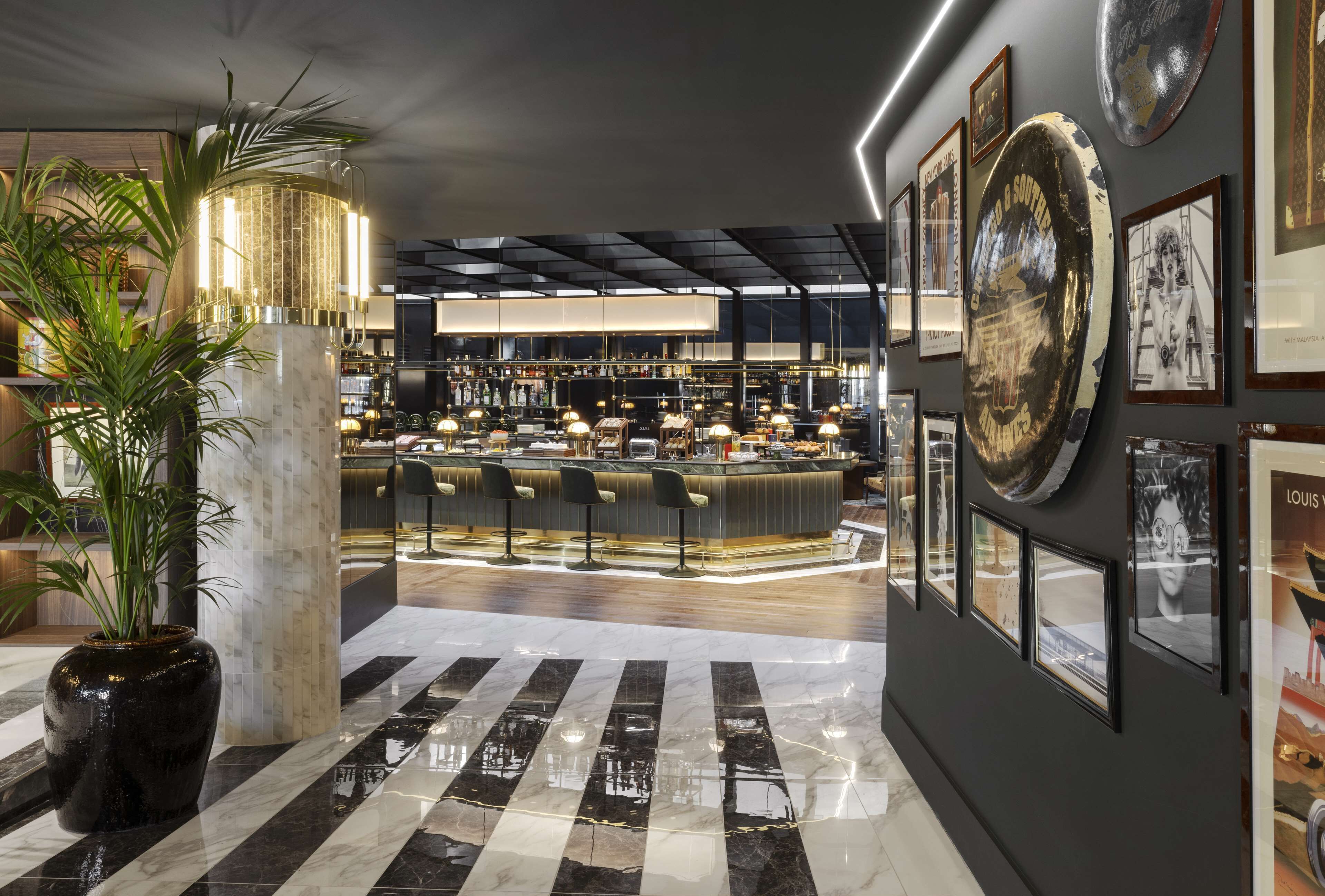 A modern bar area with a counter, seating, and a large decorative plate on the wall.