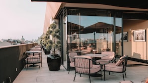 A rooftop terrace with outdoor seating, potted plants, and a view of the cityscape. - Radisson Collection Hotel, Santa Sofia Milan (Milan)