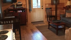 Un intérieur de chalet chaleureux comprenant une cuisine, un coin repas et un salon.