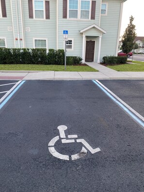 A parking lot with a handicapped parking space marked by a wheelchair symbol. - Cozy Townhome Near Disney Parks (Kissimmee)