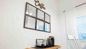 A room with a coffee sign, a table with a coffee maker, and a window with blinds. - Ranch Glam Townhome with Indoor Fireplace (El Paso)