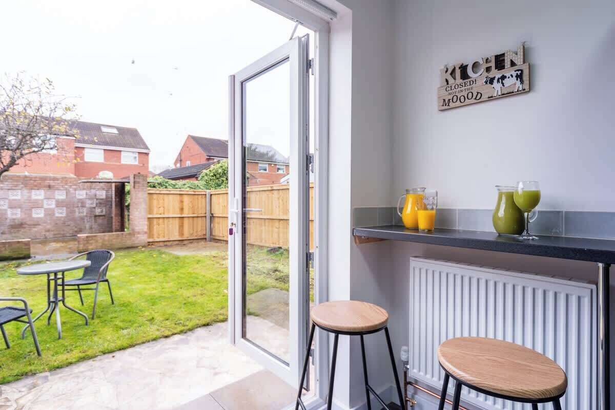 A kitchen with a white countertop, two stools, and a sign on the wall.
