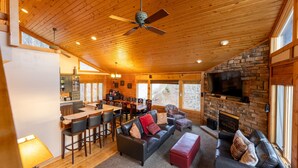 A spacious living area with a fireplace, a dining area, and a kitchen.