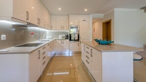 A modern kitchen with white cabinets, stainless steel appliances, and a central island. - Boavista Resort - Casa Belinda (Lagos)