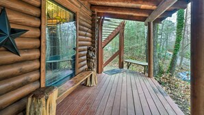 Eine Blockhütte mit einer Holzterrasse, einer Bank und einer Sternenverzierung.