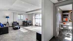 A modern living room with a sofa, coffee table, and dining area. - Falesia Beach B in Albufeira (Albufeira)
