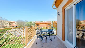 Enjoy outdoor dining or relaxation on this balcony with a clear view of the surrounding neighborhood.