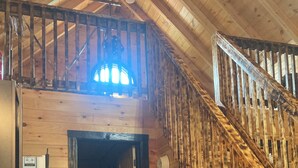 Un intérieur rustique en bois, comprenant un coin repas, un escalier et une cuisine.