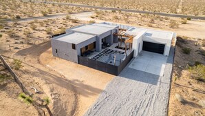 Una casa moderna con techo plano, garaje y un patio.