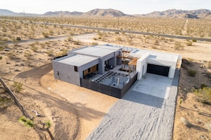 A modern house with a flat roof, a garage, and a patio area.