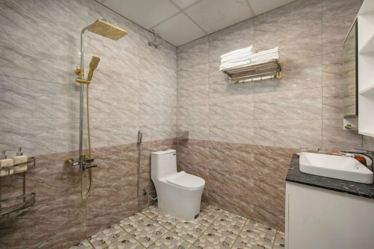 A bathroom with a shower, toilet, and sink.