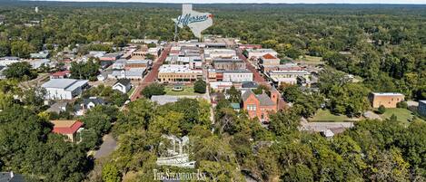 An aerial view of Jefferson, highlighting The Steamboat Inn surrounded by dense greenery and a mix of residential and commercial buildings.