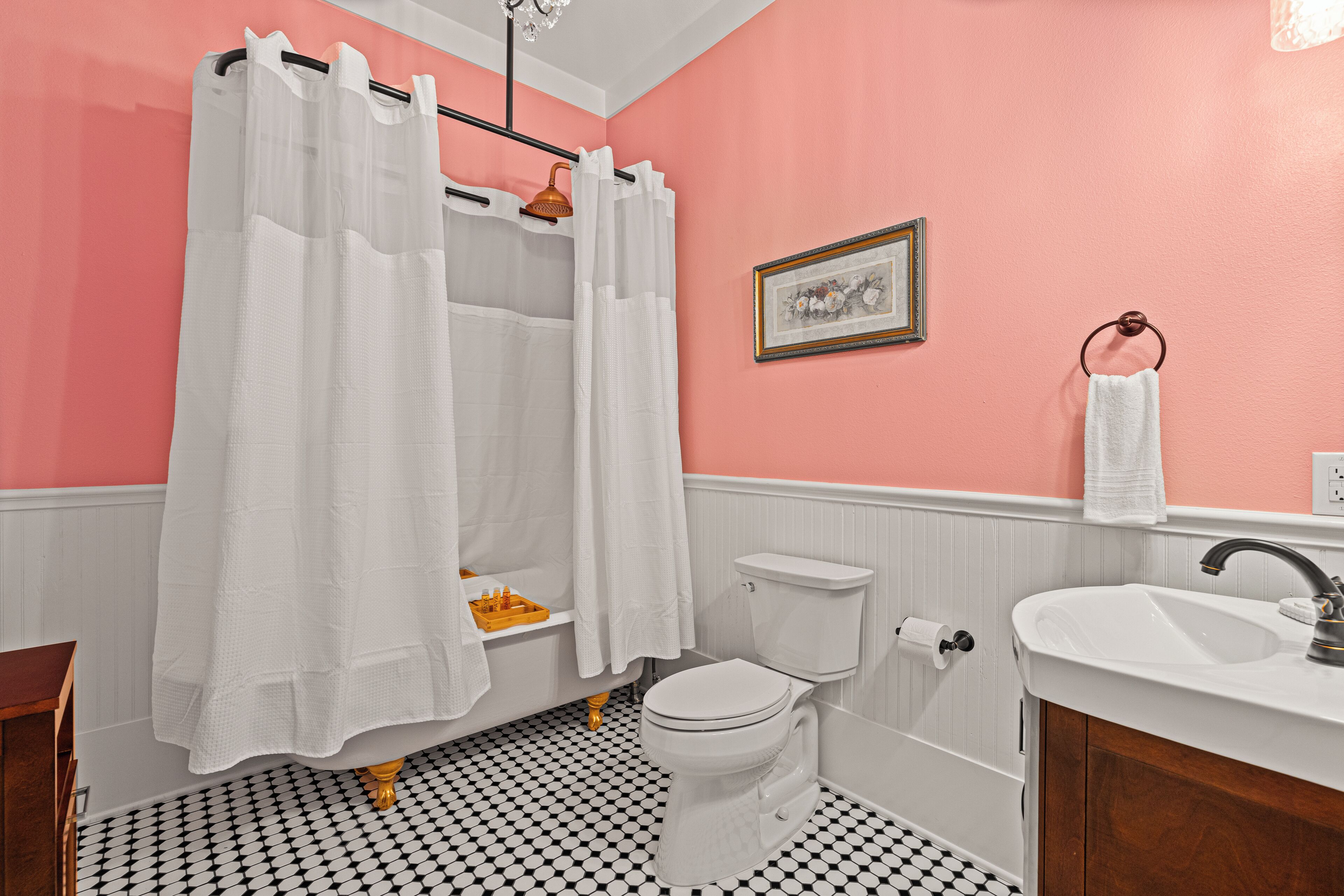 A bathroom with a white toilet, a sink, and a shower with a white curtain.