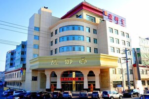 Un hotel de varios pisos con una entrada destacada y señalización.